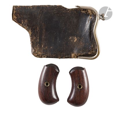 a close up of a pair of wooden revolver grips and a leather case