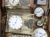 de nombreuses horloges différentes dans une boîte posée sur la table