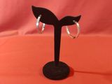 a close up of a pair of earrings on a black stand
