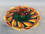 a plate with a bowl on it that has leaves on it