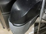 une poubelle noire posée à côté d'une poubelle en métal