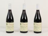 trois bouteilles de vin posées sur une table l'une à côté de l'autre