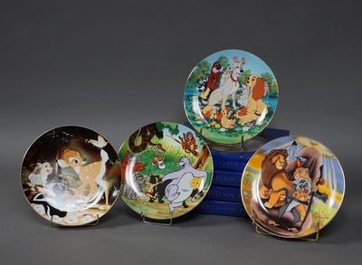 quatre assiettes disney sont empilées sur une table