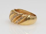 a close up of a gold ring with diamonds on a white surface