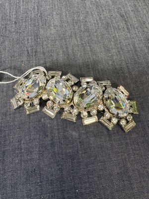 Gros plan sur un bracelet en argent et cristal posé sur une surface grise