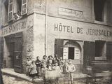 une vieille photo montrant un groupe de personnes devant un hôtel