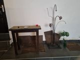 a small table with a vase on it next to a potted plant