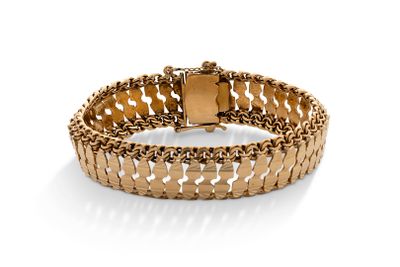 gros plan d'un bracelet en or sur fond blanc
