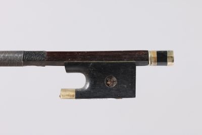 a close up of a violin bow on a white surface