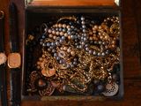 a wooden box filled with lots of jewelry on a table
