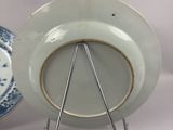 a white plate on a stand with a blue and white plate on it