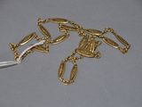 a close up of a gold chain with a white cord attached to it