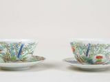 two cups and saucers with floral designs on them