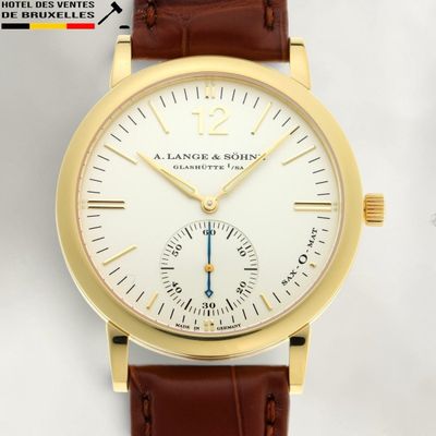 un gros plan d'une montre-bracelet en or avec un bracelet en cuir marron