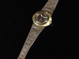 an image of a watch on a black surface with a black background