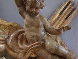a statue of a child sitting on top of a mirror