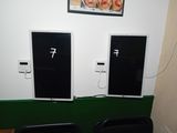 deux téléviseurs posés sur une table verte