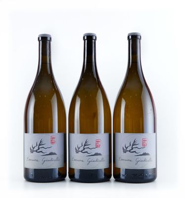 trois bouteilles de vin posées les unes à côté des autres sur une surface blanche