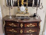 une horloge posée sur une commode dans une pièce
