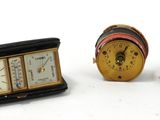 une petite horloge posée à côté d'une petite boîte