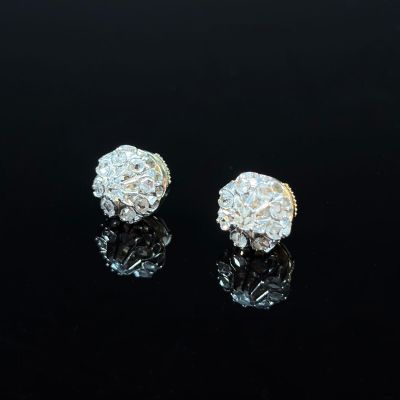 a pair of diamond earrings on a black surface