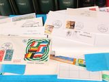 a pile of mail sitting on top of a desk next to a pile of books