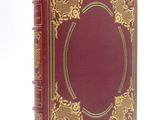 un vieux livre rouge aux tranches dorées et à la bordure dorée
