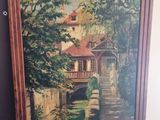 an oil painting of a house by a river in a wooden frame