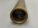an old brass telescope with a black lens on a white surface