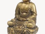 statue of a seated buddha on a rock on a white background