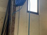 une photo d'une pièce avec un ventilateur de plafond et une fenêtre