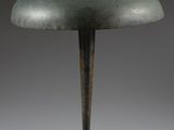 a green table lamp with a metal base and a black cord