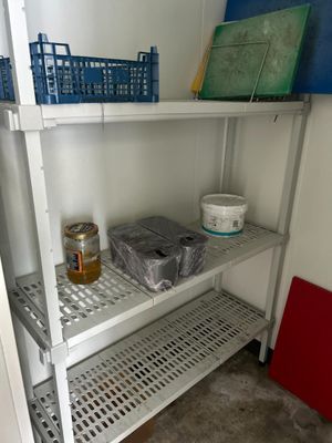 une étagère métallique sur laquelle sont posés des paniers, dans une pièce