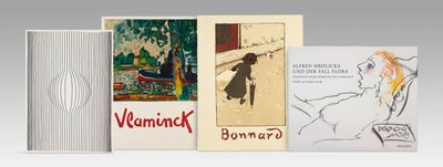 several books are lined up on a white surface with a gray background