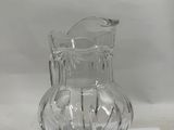 a clear glass pitcher sitting on a white surface