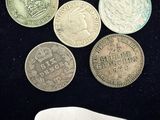 six pièces de monnaie britanniques différentes sont posées sur une surface noire, accompagnées d'une étiquette de prix
