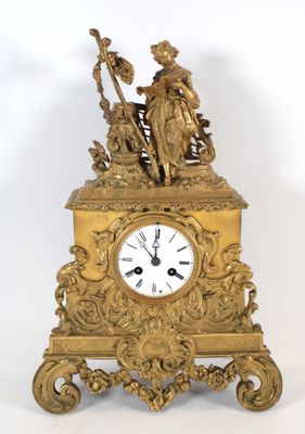 une horloge en or surmontée d'une statue