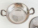 a silver bowl with a handle and a picture on the side