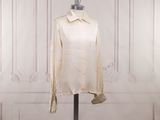 an image of a white shirt on a mannequin stand in front of a white wall