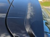 a close up of a black car with a roof spoilor