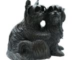 statue représentant deux chiens assis sur une souche d'arbre percée d'un trou au milieu