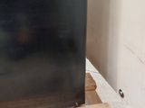 a black refrigerator sitting on a pallet in the middle of a room