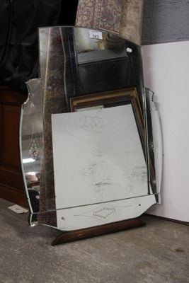 un miroir appuyé contre le mur, à côté d'un réfrigérateur