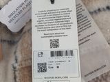 a label on the tag of a sweater hanging on a hanger