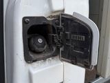 a gas pump in the door of a white truck