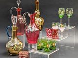 many different colored glass vases and glasses on display