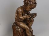 two figurines of a boy sitting on a box