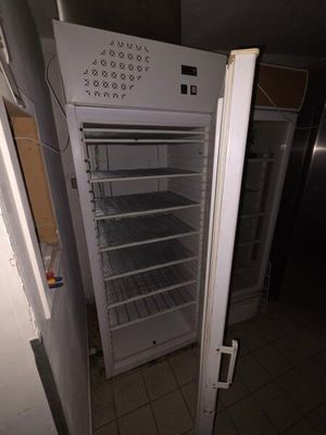 un réfrigérateur ouvert au milieu d'une cuisine sale