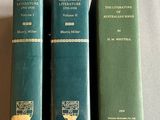 trois livres verts posés les uns à côté des autres sur une table