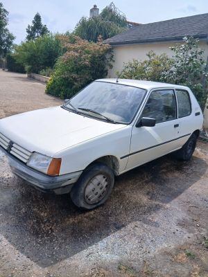 une voiture blanche garée sur la terre battue